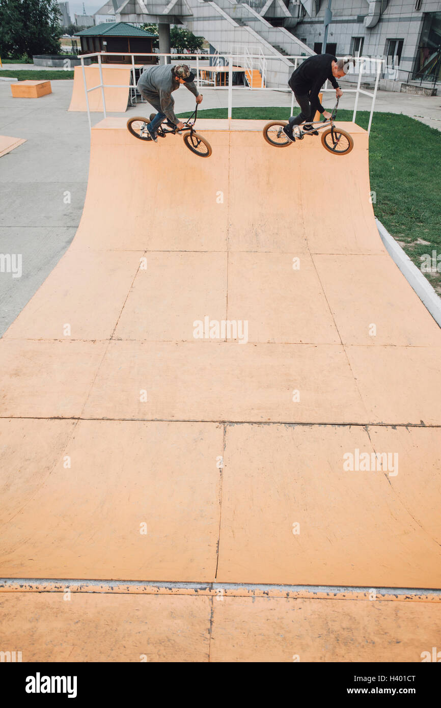 Angolo di alta vista di amici in bicicletta sulla rampa di skate park Foto Stock