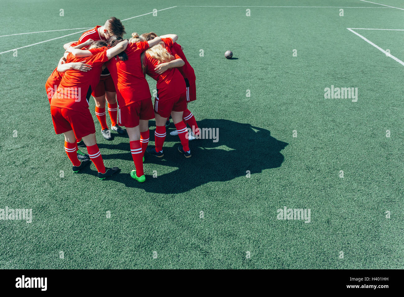 Angolo di alta vista dei giocatori di calcio huddling sul campo Foto Stock