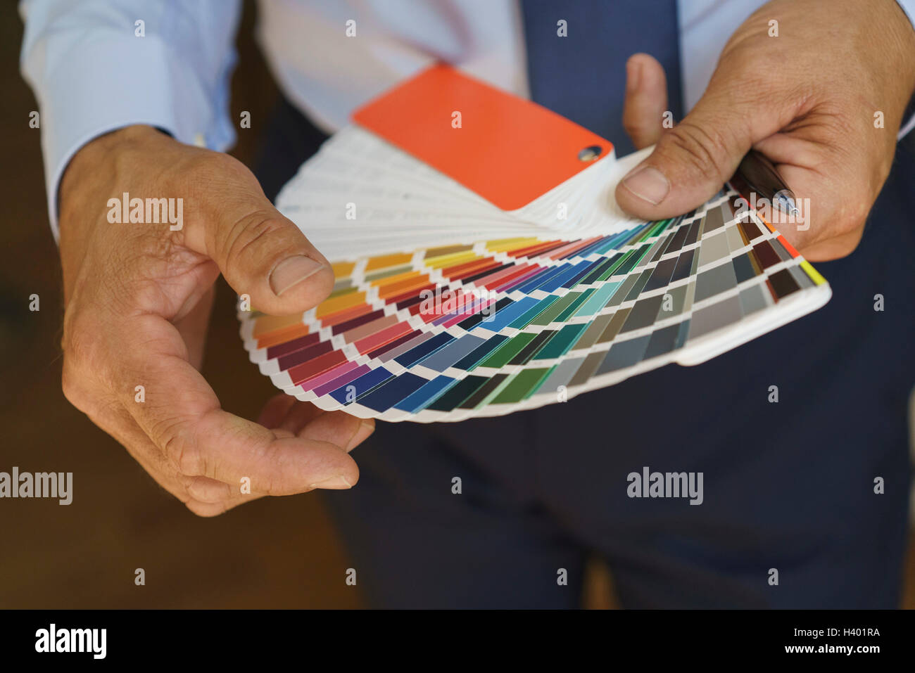 Sezione mediana di imprenditore tenendo i campioni di colore in ufficio Foto Stock