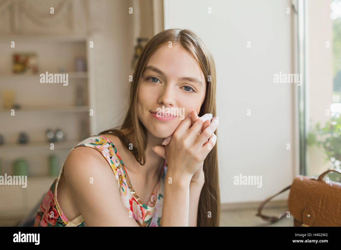 Ritratto di sorridente bella donna appoggiata sulla tavola da una finestra Foto Stock