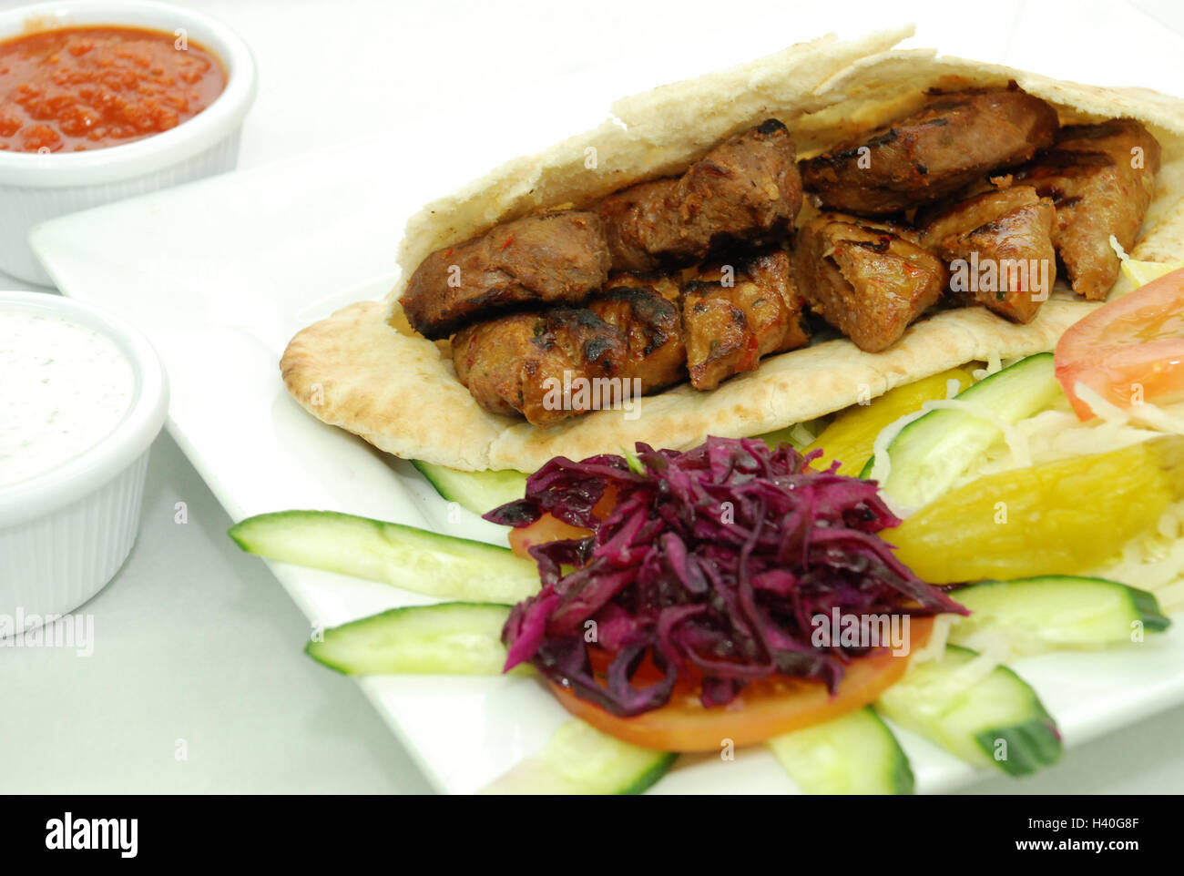 Agnello shish kebab in pita con insalata con salsa di peperoncino, salsa di aglio Foto Stock