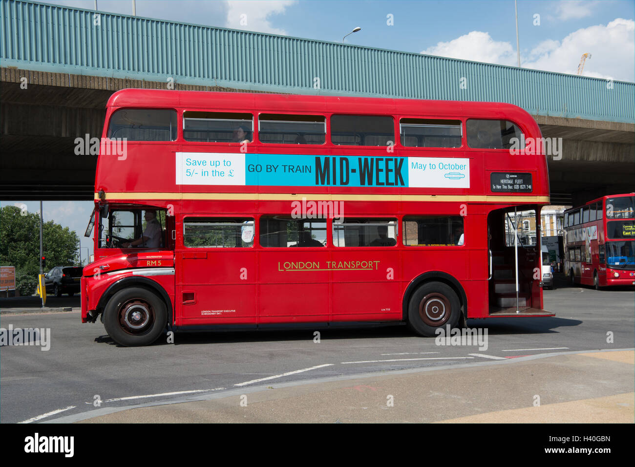 Vicino a vista di lato di un classico AEC autobus Routemaster in London Transport livrea circa passare sotto la Canning Town cavalcavia Foto Stock