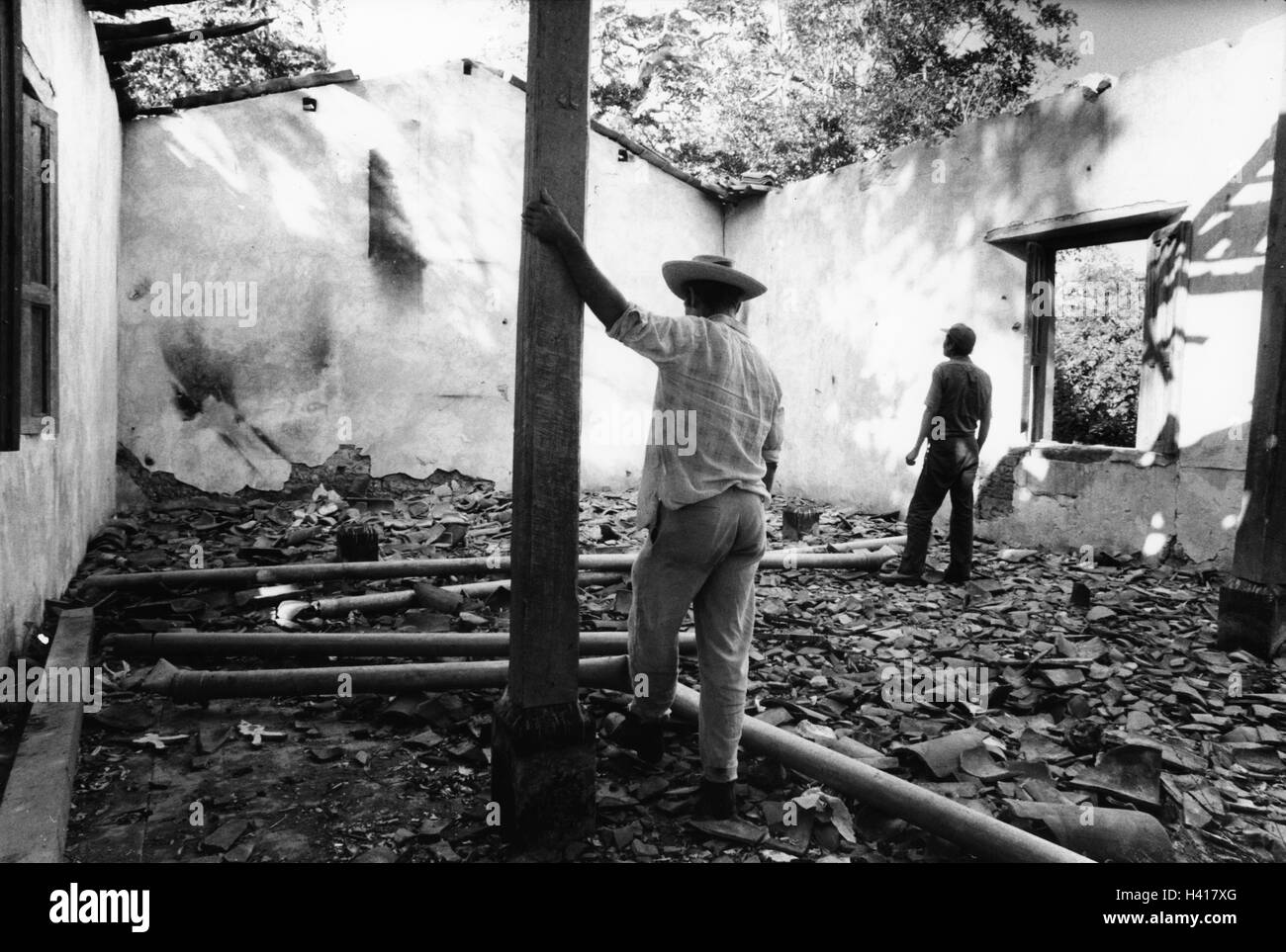 CHALATENANGO, EL SALVADOR, FEB 1984: - all'interno del FPL Guerrilla zone di controllo - Gli abitanti di un villaggio di stand nelle rovine della loro chiesa, distrutta durante una operazione militare nella zona Foto Stock