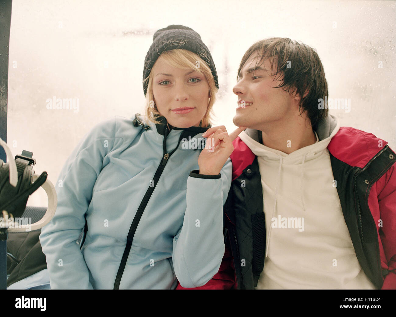 Coppia giovane, cade nell'amore, gesto, abbigliamento invernale, ritratto, vacanza, vacanze sugli sci, vacanza invernale, stagione invernale, vestiti, invernale, neve vestiti, abbigliamento da sci, ski-lift, sollevamento, 20-30 anni felici, tease, emancipazione, flirt dominante, divertimento, vacanze, l Foto Stock