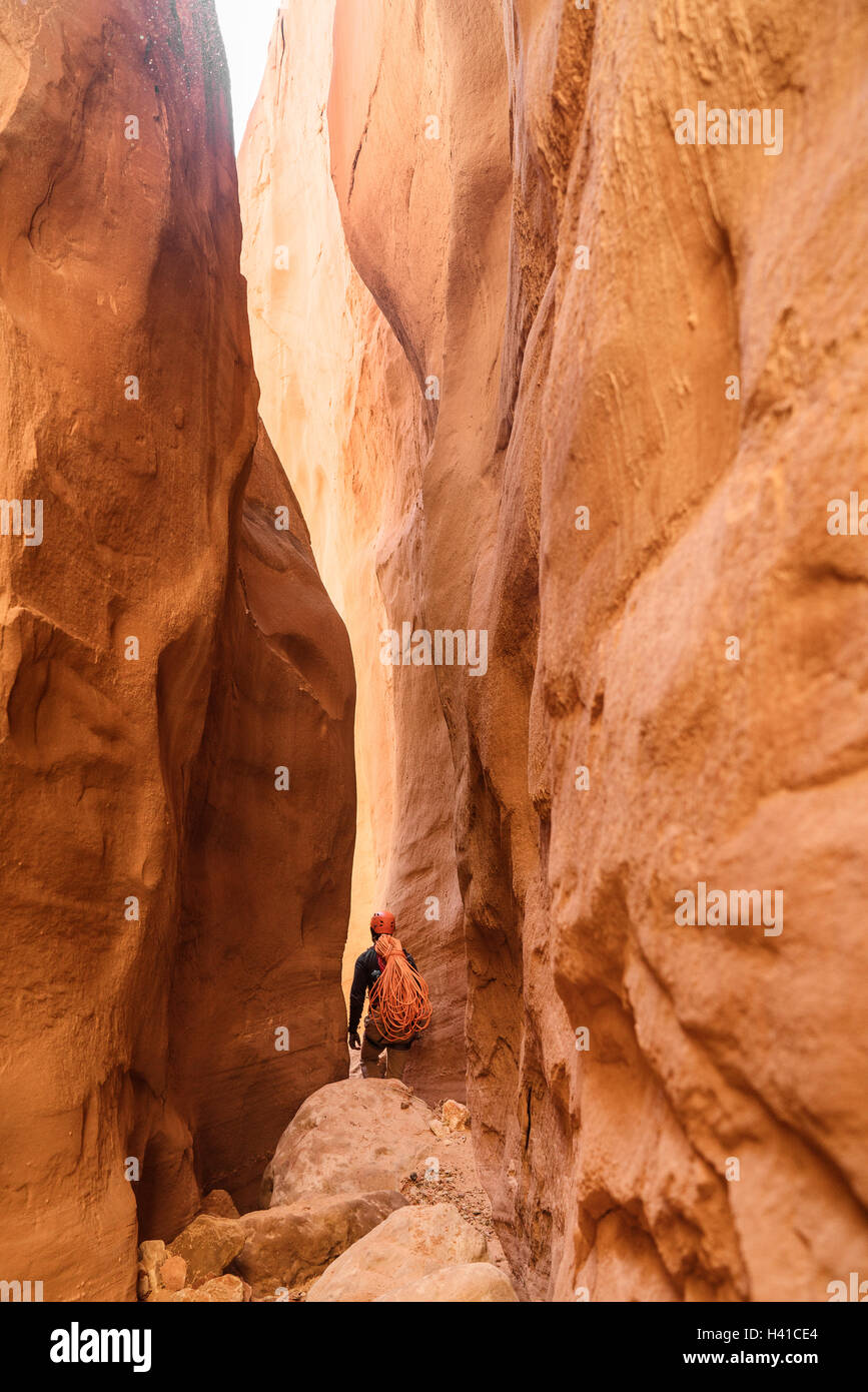 A scalatori fa il suo modo attraverso una Red Rock Canyon slot nel sud dello Utah Foto Stock