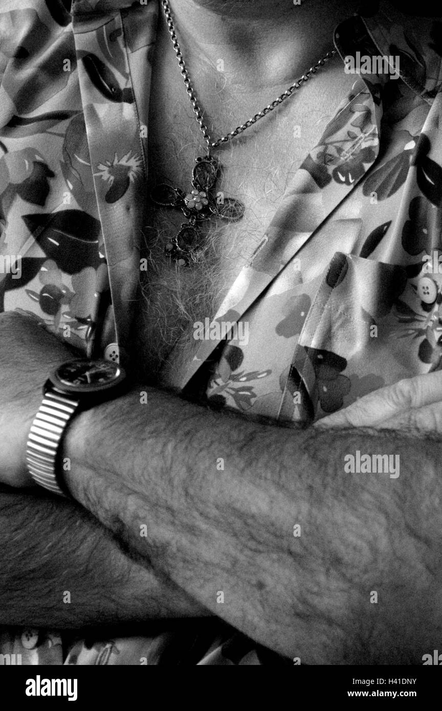 L'uomo, dettaglio, braccia incrociate, b/w, molto vicino, maglietta apertamente, torace sui peli peli mammaria, catena, collana, gioielli, croce, clock, orologio da polso, posizione, posizione di auto-con sicurezza e fiducia in sé stessi Foto Stock