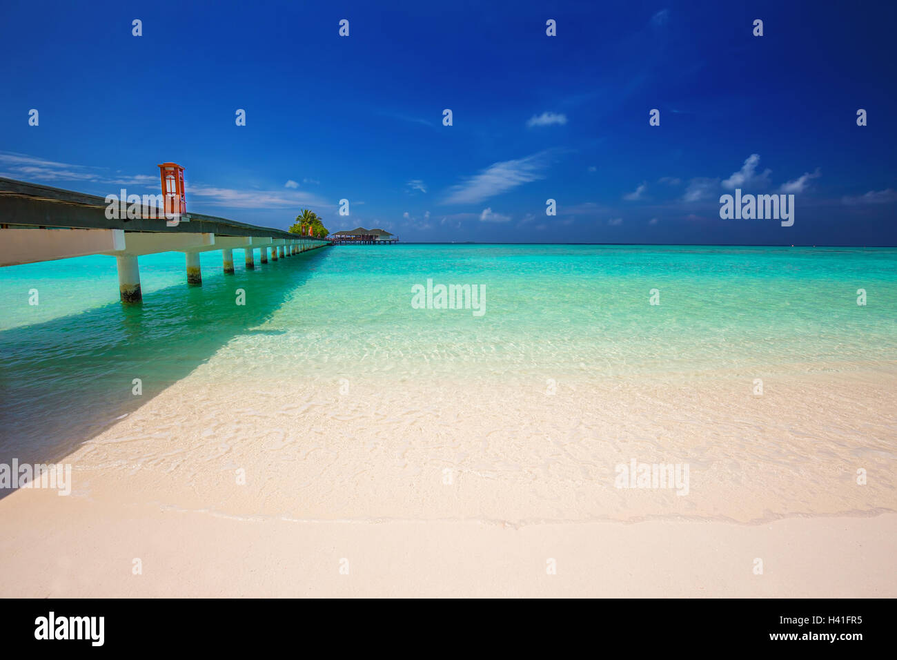 Ponte che conduce al bungalow Overwater in laguna blu intorno alle Maldive tropicale isola Foto Stock