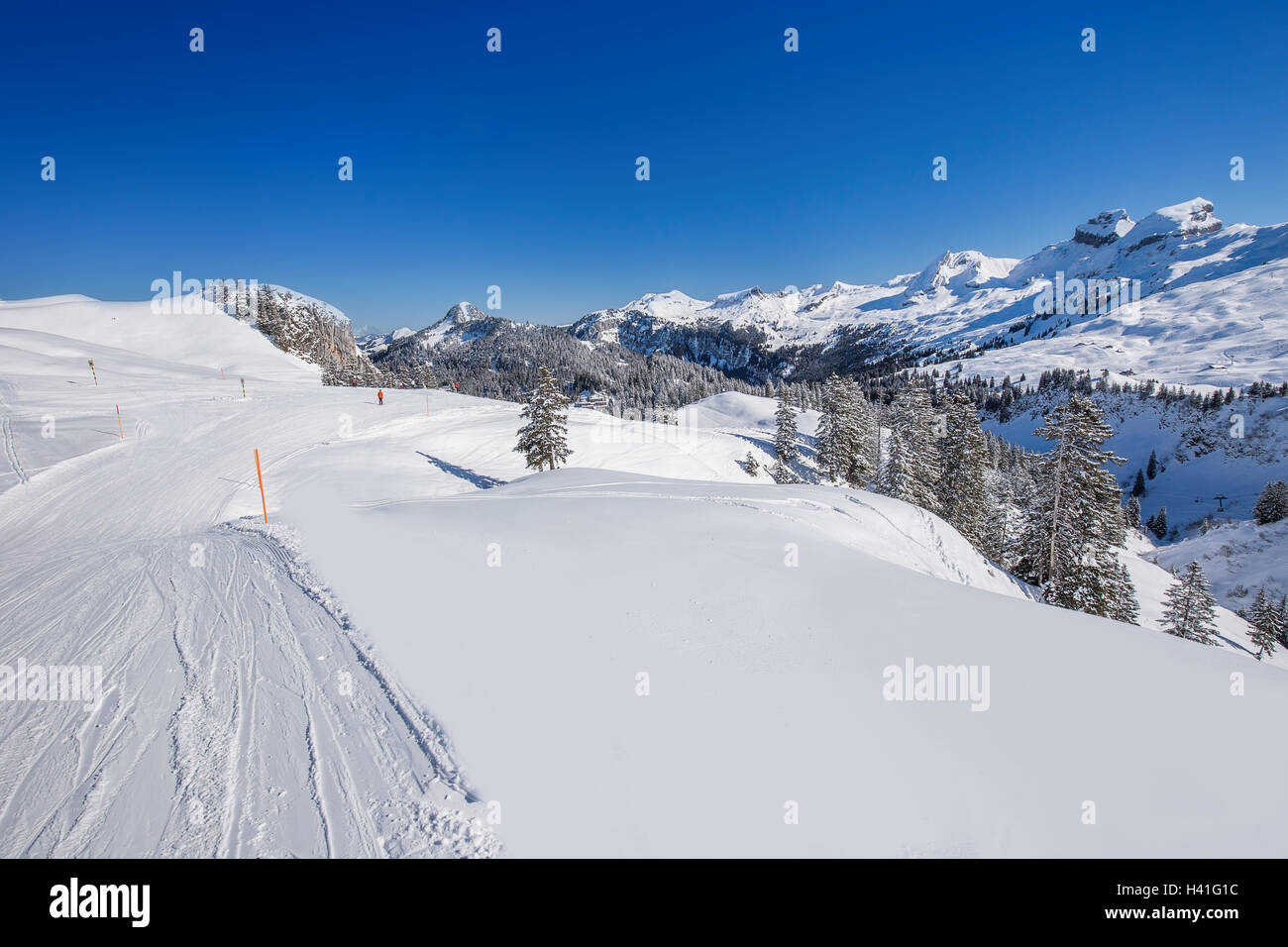 Vista ti sciatori sulle piste da sci e sulle Alpi Svizzere coperti dalla nuova neve visto da Hoch-Ybrig ski resort, la Svizzera centrale Foto Stock