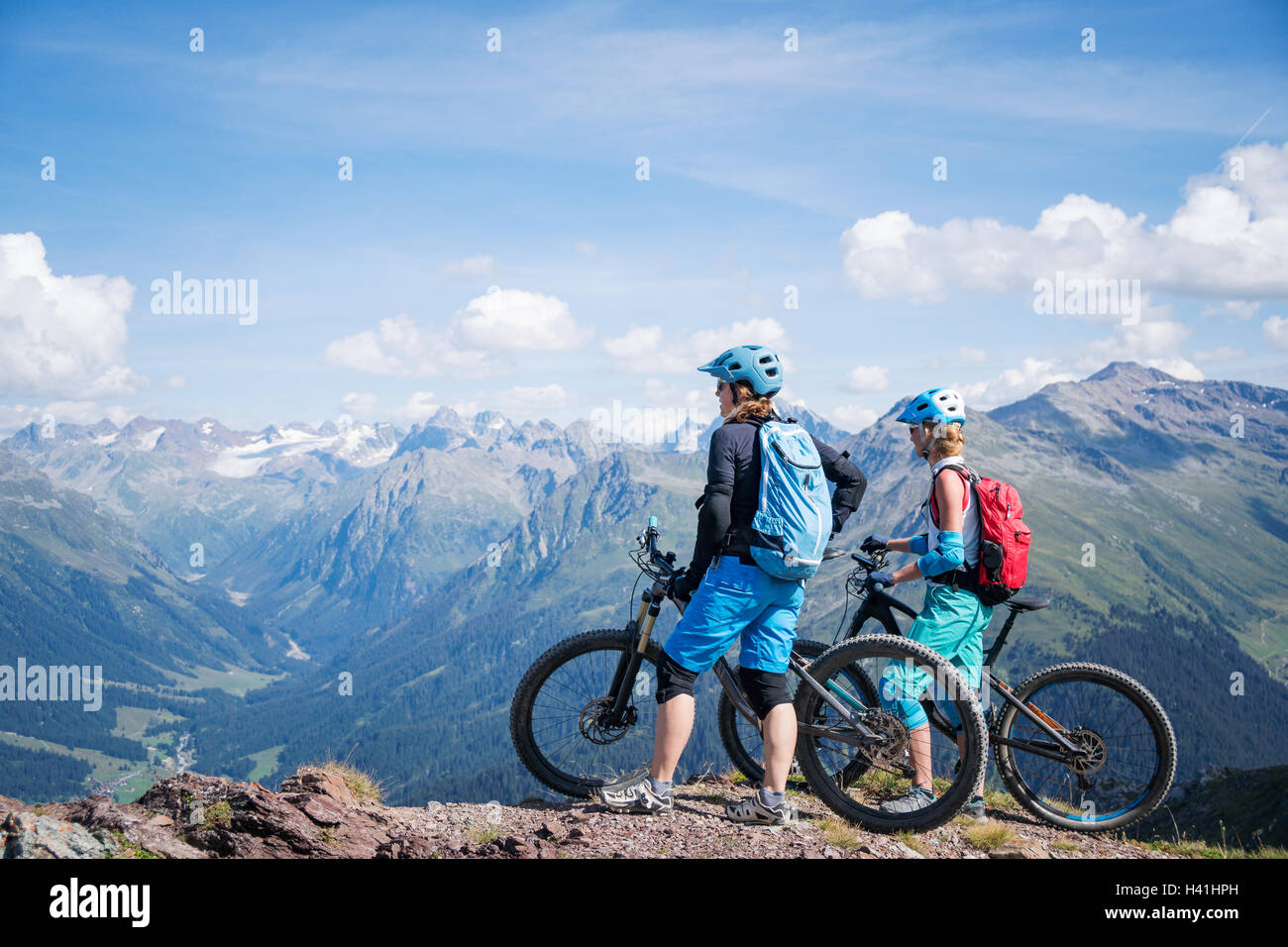 Due donne in piedi con la mountain bike nelle alpi svizzere, Davos, Grigioni, Svizzera Foto Stock