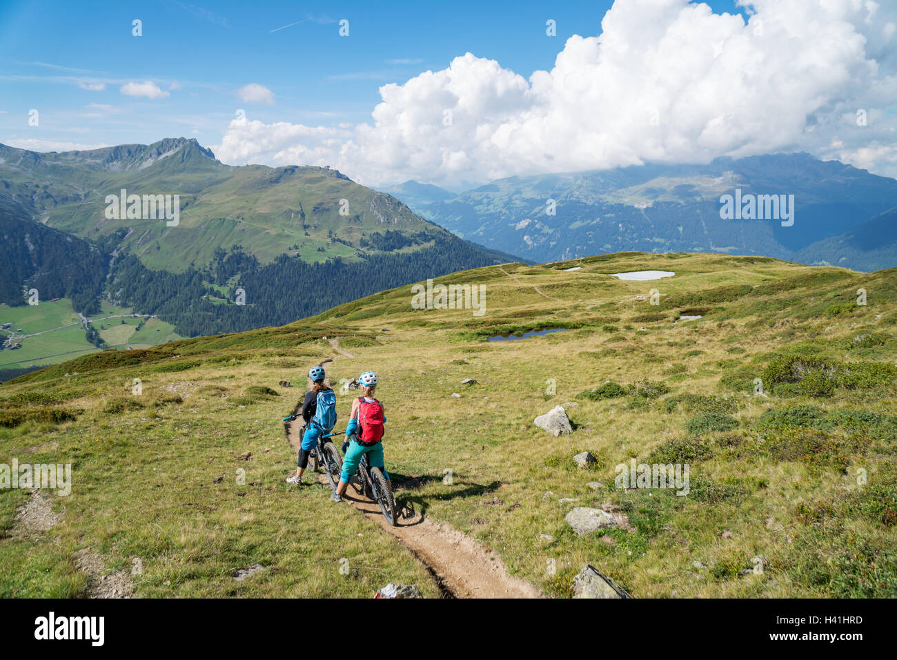 Due donne in mountain bike nelle alpi svizzere, Davos, Grigioni, Svizzera Foto Stock