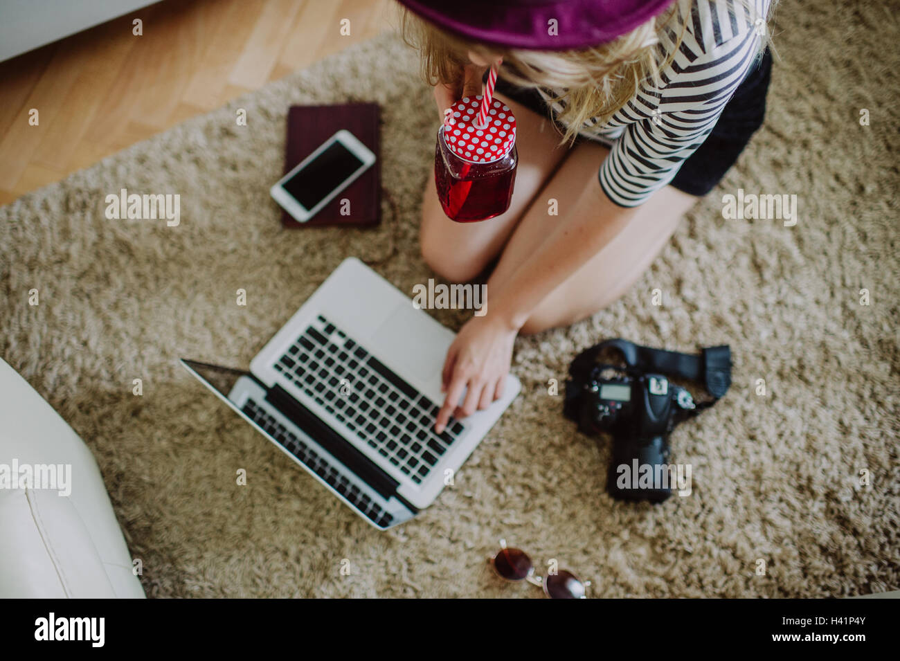 Ragazza seduta sul pavimento con notebook e fotocamere Foto Stock