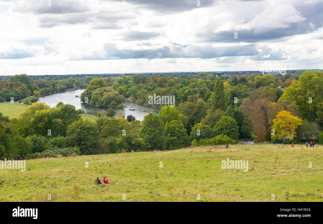 Irriconoscibile persone godendo della vista sul fiume Tamigi in una giornata nuvolosa in Richmond Park. Foto Stock