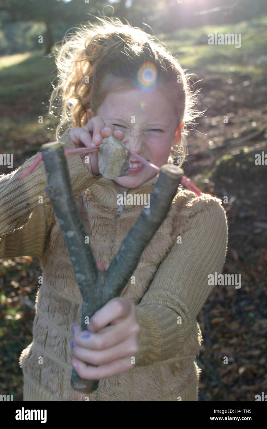 Le ragazze, catapulte, AIM, play legno ritratto, stagione autunno, autumnally, bosco di latifoglie, bambino, infanzia, 4 - 9 anni, arma, pietra, pericolosamente, ridere, sparare, pericolo di pregiudizio, esterno Foto Stock