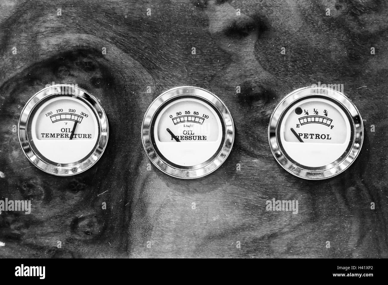Temperatura olio e pressione olio indicatori di livello sul cruscotto in radica di un'auto d'epoca. Foto Stock
