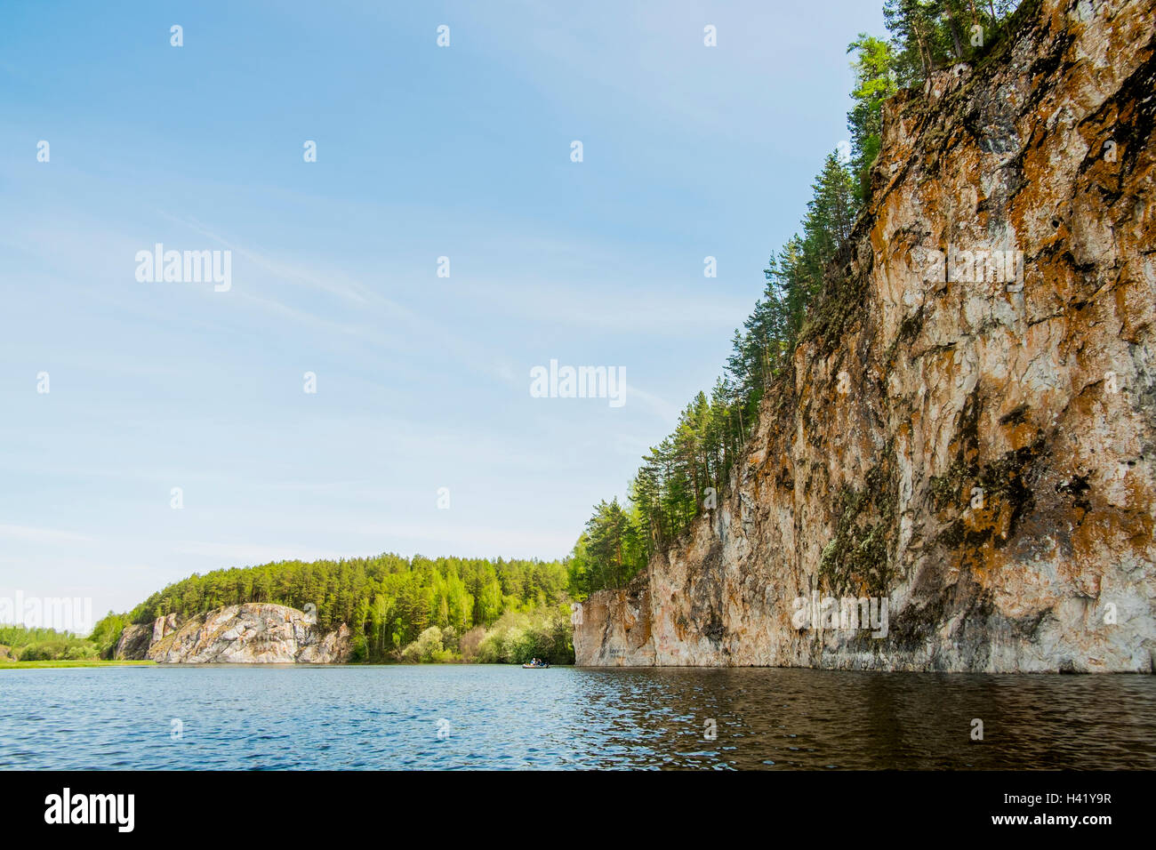 Distanti zattera gonfiabile sul fiume vicino a cliff Foto Stock