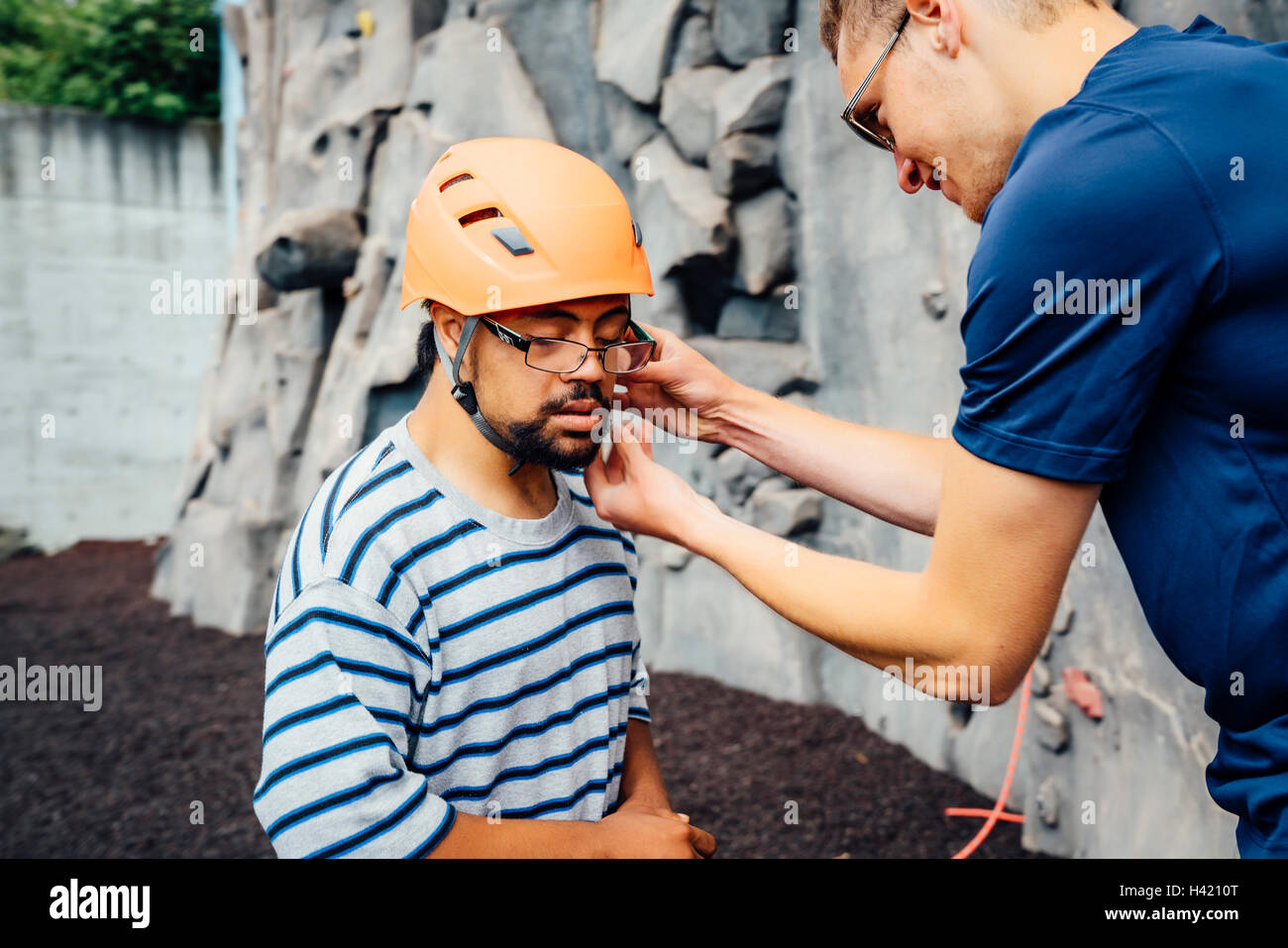 L'uomo aiutando rocciatore fissare il casco Foto Stock