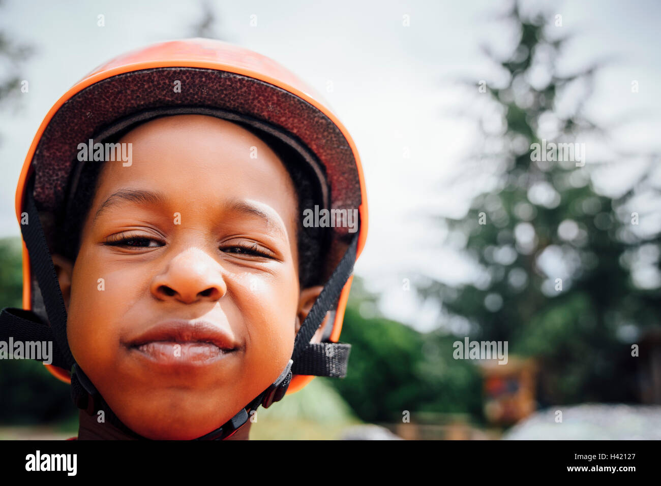 Ghignanti Black boy indossando il casco Foto Stock