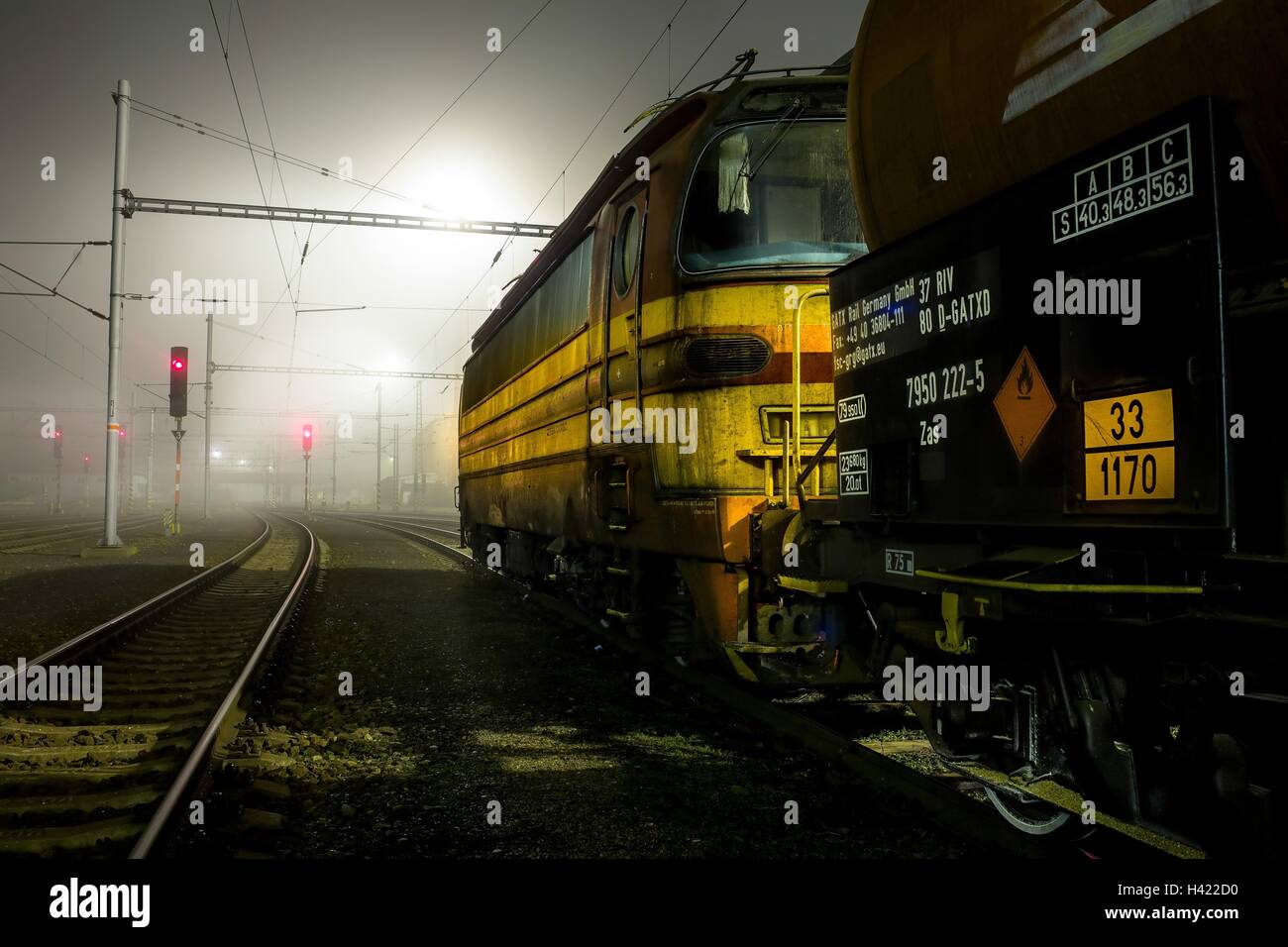 Locomotiva elettrica in attesa su piste con carico dietro Foto Stock