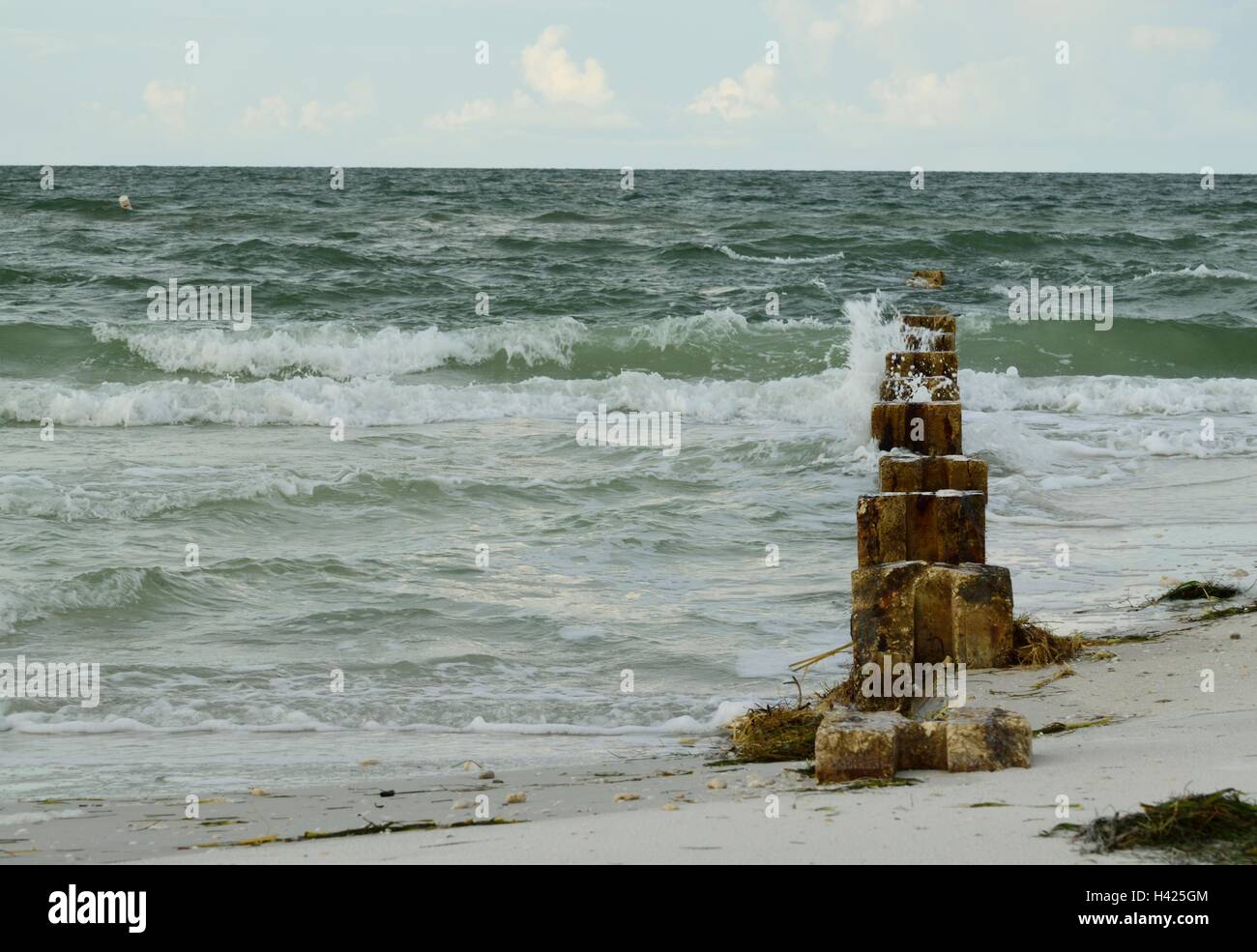 Onde pesanti in rotolamento su vecchi pilastri di cemento. Foto Stock