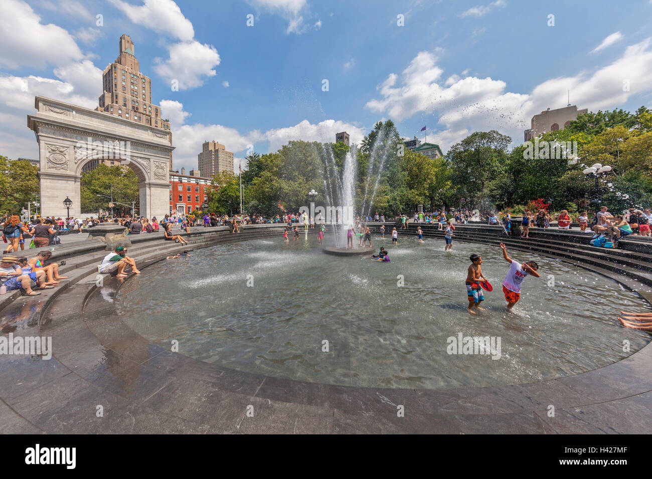 Washington Square Park Arco nella città di New York e persone che giocano nella fontana di acqua. Foto Stock