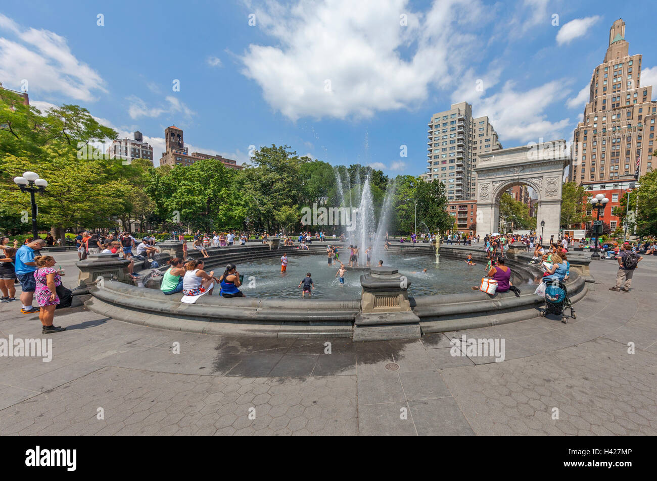 Washington Square Park Arco nella città di New York e persone che giocano nella fontana di acqua. Foto Stock