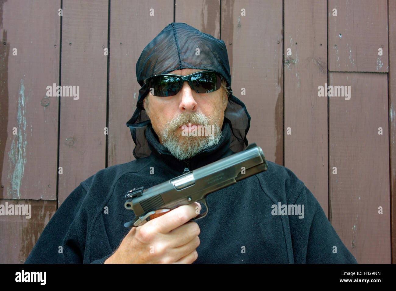 Una banda criminale stati gangster brigante o mugger puntando un puledro 45 pistola automatica Foto Stock