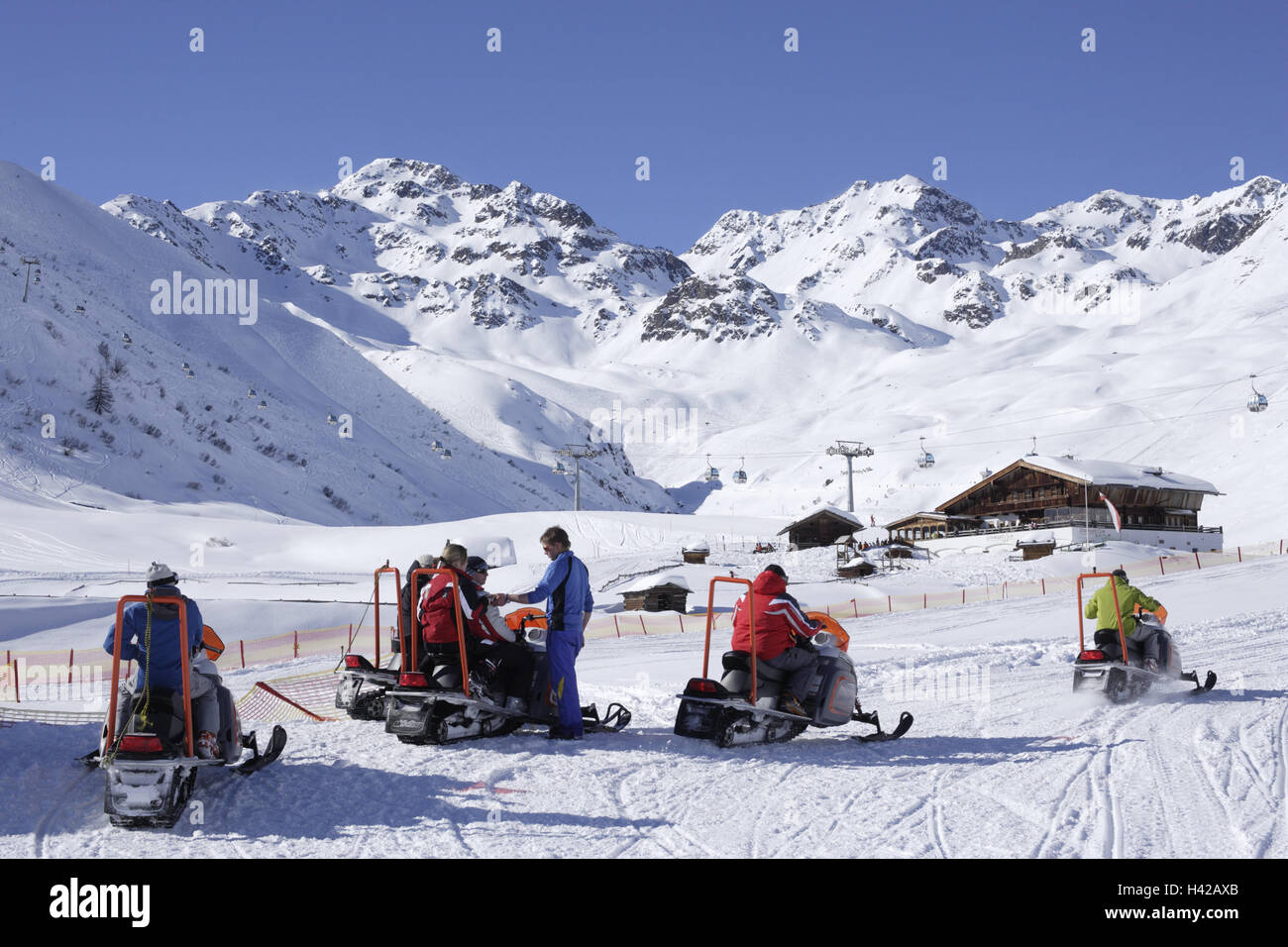 Austria, Tirolo, Serfaus-Fiss-Ladis, zona sciistica, innevate Skidoos, driver nessun modello di rilascio, alpi, montagne, montagne, stagione inverno, neve Comprensorio sport invernali, turismo, turismo, capanna in legno, cielo blu, senza nuvole, sole, Skidoofahrer, tour, actio Foto Stock