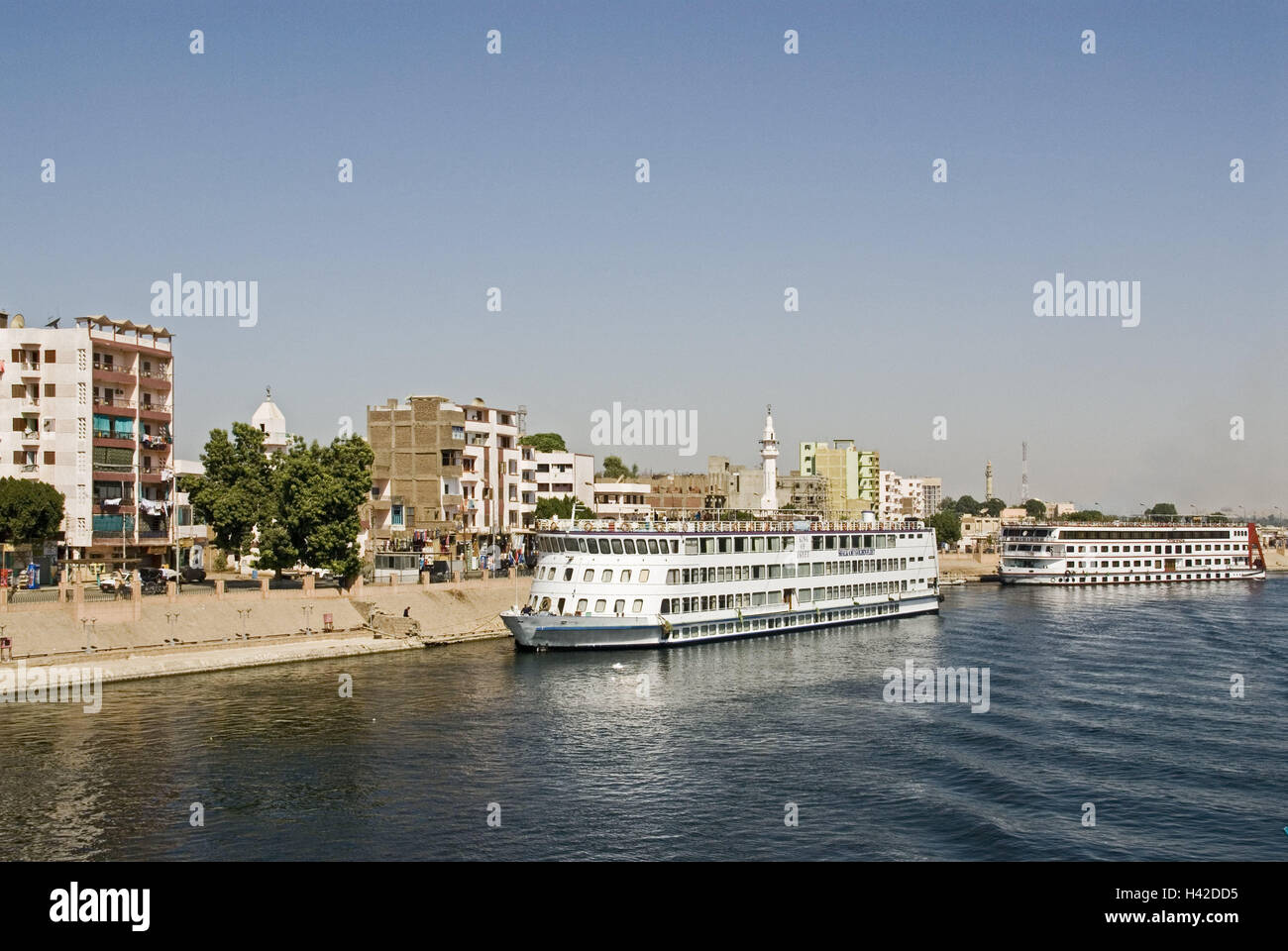 Egitto, Edfu, vista città, il Nilo, navi da crociera, Alto Egitto, città, case, edifici, fiume, navi Navi vacanze, navigazione, viaggio in battello, destinazione, turismo, Foto Stock