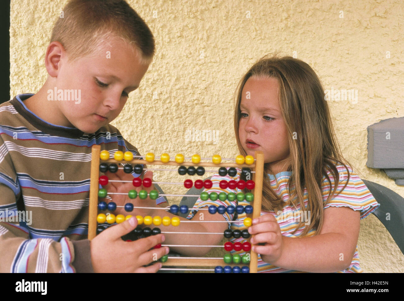Ragazzo, ragazza, slitta regola, imparare i fratelli, 6 - 8 anni, alunni, scolari, abaci, gioco, conteggio, considerare, concentrazione, lavoro, aggiungi, addizione, sottrazione, sottrarre, scopri di seguito, plus, somma, icona, scuola, formazione permanente e istruzione scolastica, educ Foto Stock