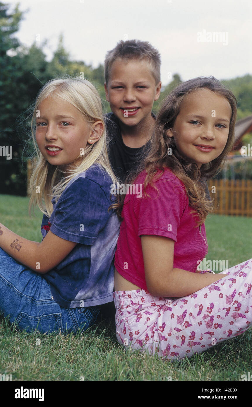 Le ragazze, boy, sedersi, prato, Felice, 10 - 13 anni, bambini, amici, amicizia, cricca, gioia, insieme, coesione, comunità, tempo libero, vacanze, ragazze, torna sul retro, infanzia, naturalezza Visualizza fotocamera, estate, all'esterno, Ti4 Foto Stock
