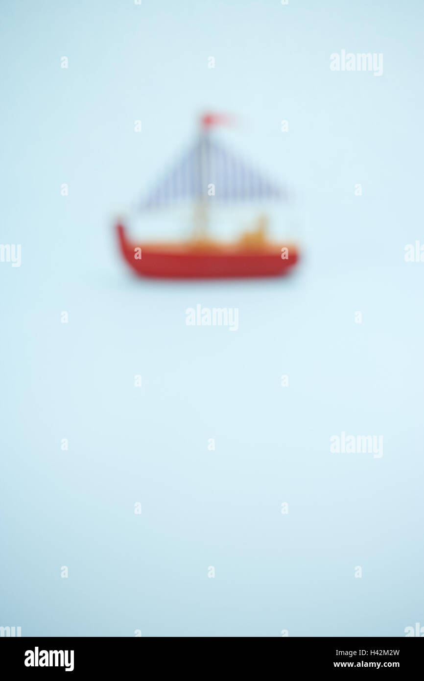 Giocattolo sfocati in barca a vela su sfondo blu Foto Stock