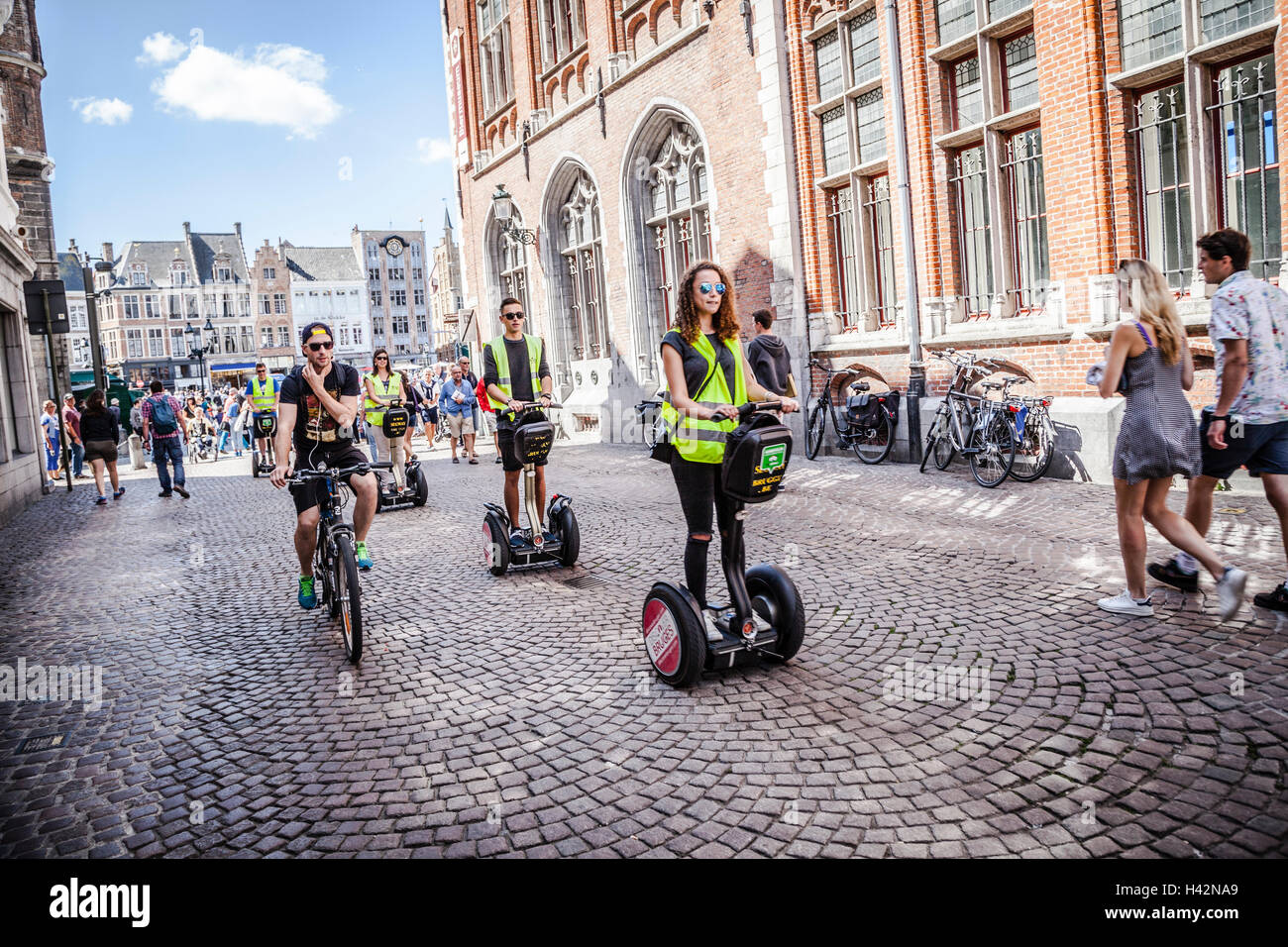 I turisti di marcia Segway per le strade del centro della città di Bruges, Belgio. Foto Stock