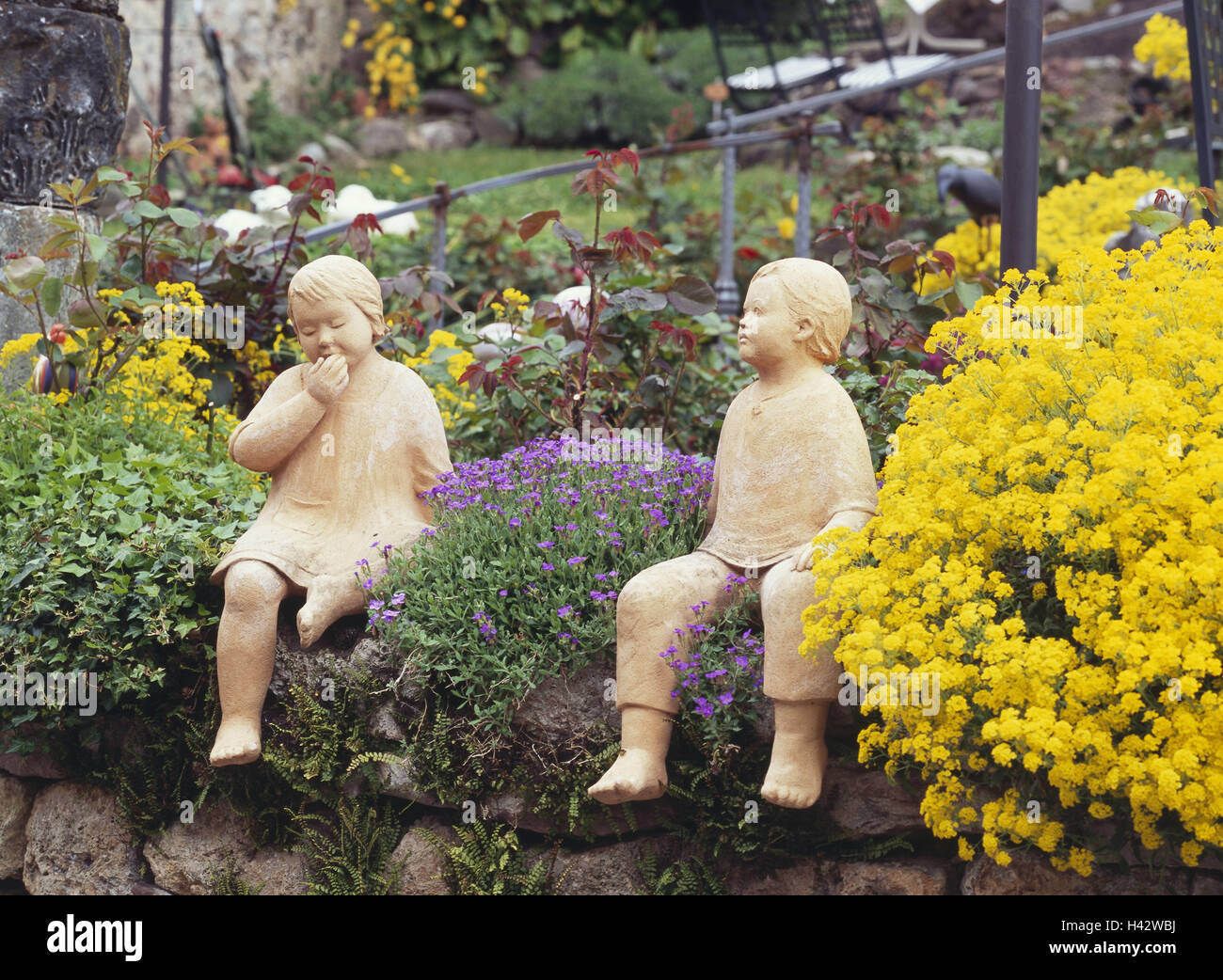 Il giardino di pietra, fiori, giardino figure, bambini, mura difensive, muratura, giardino, giardino di pietra, foreground, figura, due figure, tono figure, bambini, bambine, abito, ragazzo, pantaloni, piedi, sit, crescere rampante, seduti fianco a fianco, insieme, coltivati in pietra Foto Stock