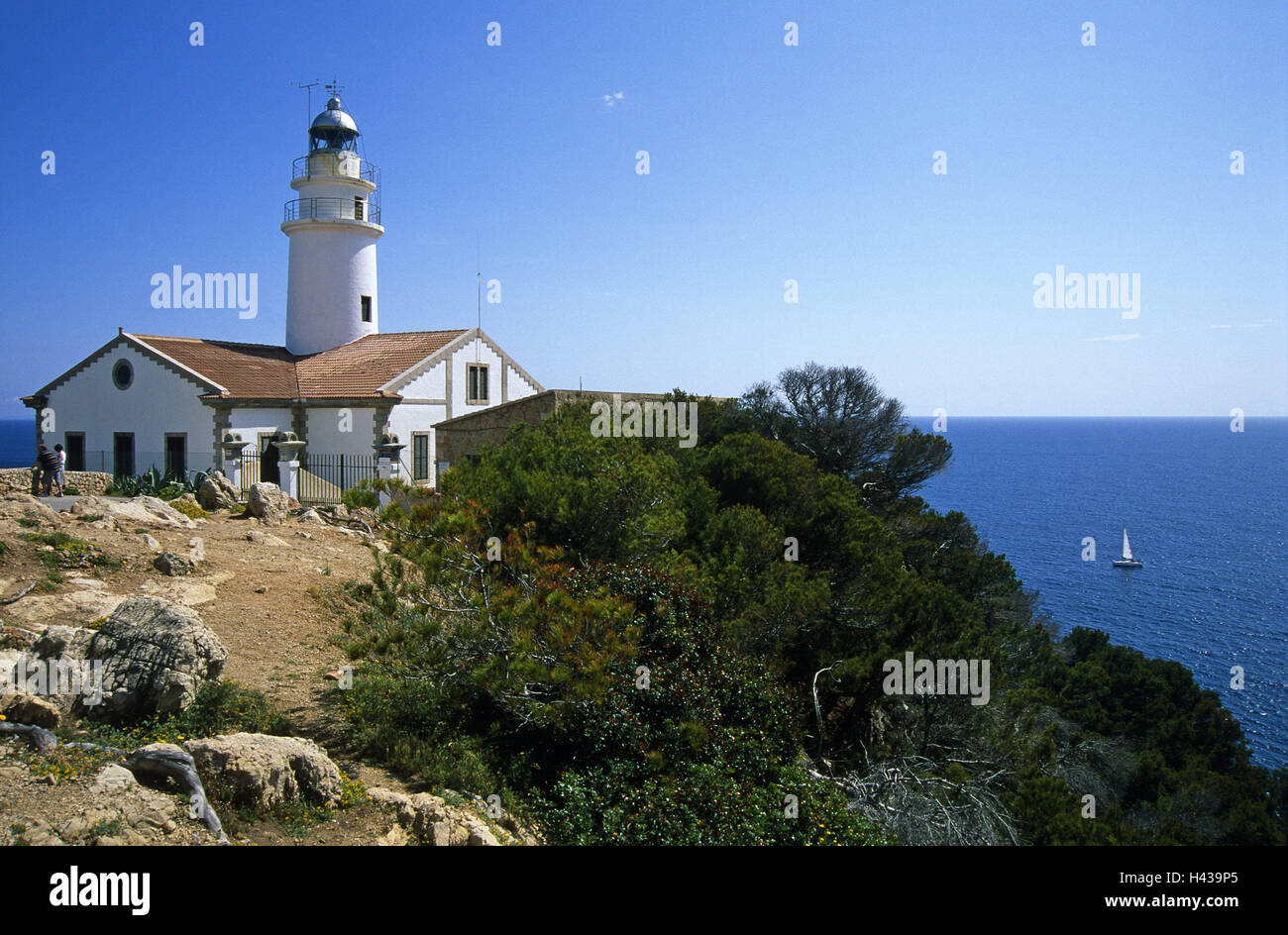 In Spagna, le isole Baleari, isola di Maiorca, Cala Ratjada, faro, esterno, isole Baleari isola, isola di Maiorca, torre di vedetta sul mare, figura, orientamento orientamento della nave, il luogo di interesse, turismo, turistico, persona, cielo, mare blu, barche a vela e il sole, Foto Stock