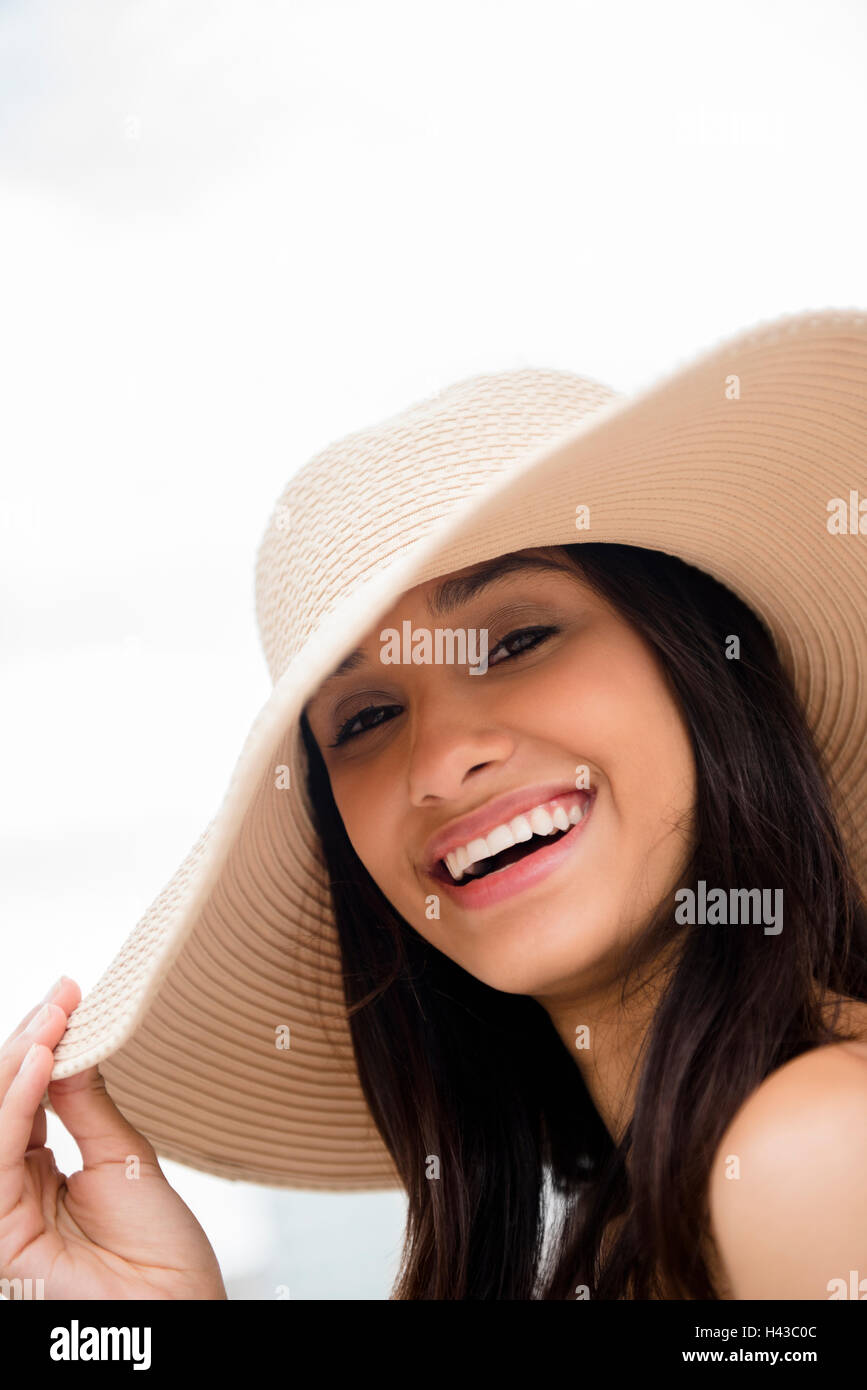 Sorridente razza mista donna che indossa cappello per il sole Foto Stock