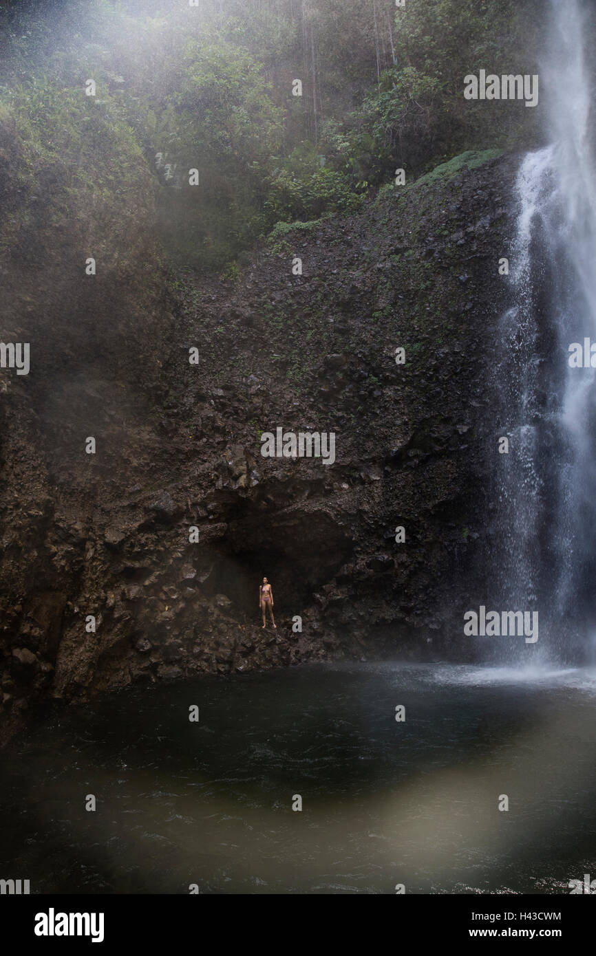 Razza mista donna in piedi vicino alla piscina a cascata Foto Stock