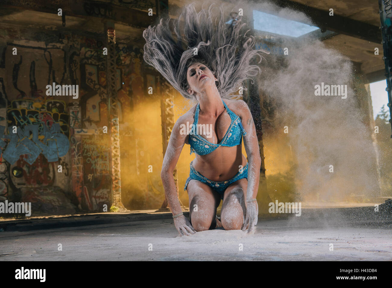 Una danzatrice del ventre tossing capelli con polvere Foto Stock