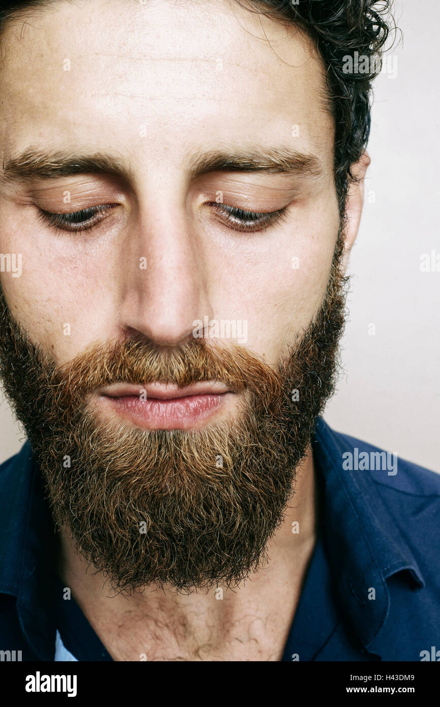 Uomo caucasico con la barba guardando verso il basso Foto Stock