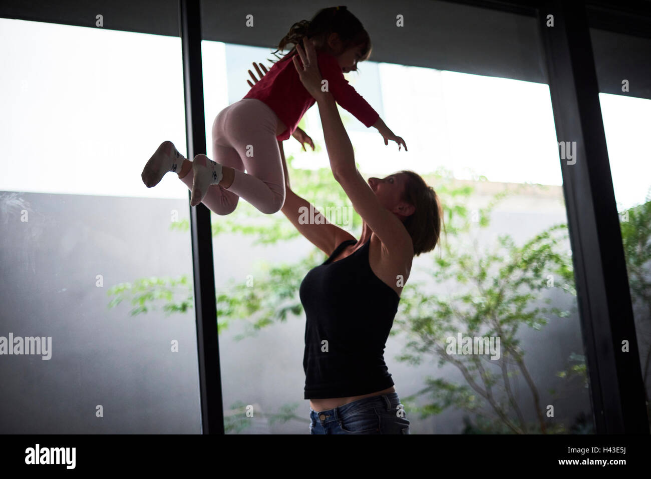 Giocoso ispanico madre figlia di sollevamento Foto Stock