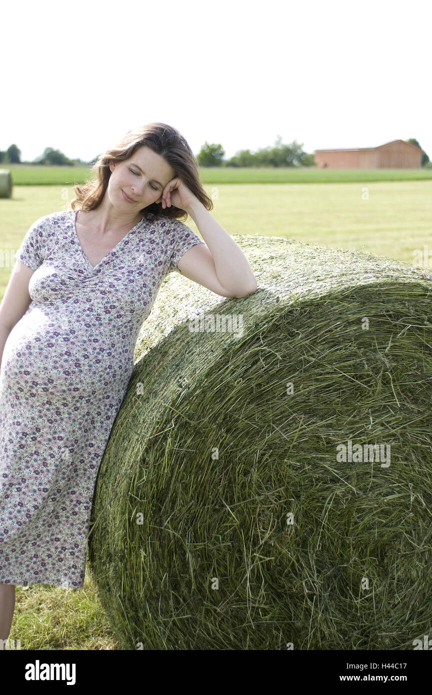 Donna incinta, fieno balle rotonde, magro, sorriso, Foto Stock