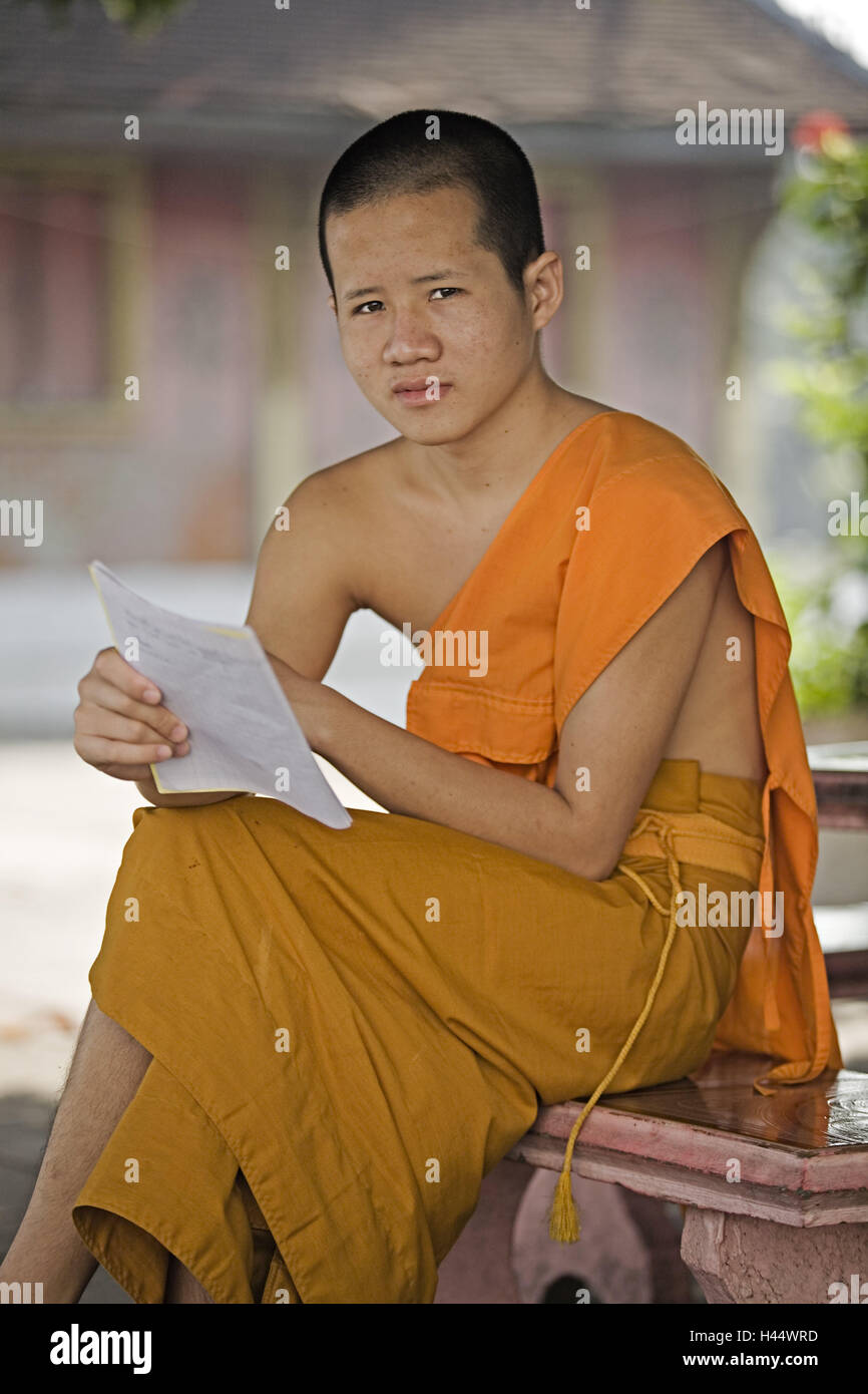Asia, Laos, Luang Prabang, monaco, leggere, fede, religione, buddismo buddisti, persone, uomo giovane, sedersi, abitudine, Lettera, Foto Stock