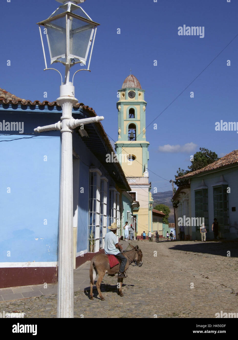 Plaza Mayor, Street, sullo sfondo la chiesa di San Francisco de Asis, Trinidad, Cuba, meta di vacanza, destinazione dei Caraibi, turismo, vacanze, vista città, centro città, luoghi interesse, luminosamente, architettura, edilizia, strutture storicamente, Steeple, torre San-Francisco-de-Asis lanterna, Lampione, scene di strada, persona, passante, spurgare, asino, equitazione animale, persona, passante, UNESCO-patrimonio culturale mondiale, Foto Stock