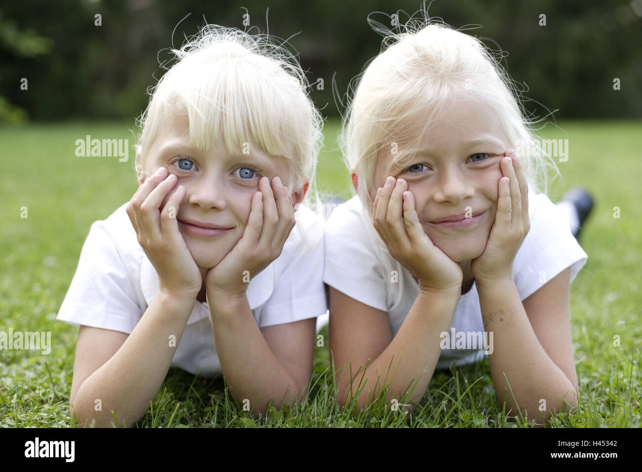 Le ragazze, due, prato, giacciono, sorriso affiancati, visualizza fotocamera, aggiungere il supporto verticale, a persona, bambini, bionda, fratelli, sorelle, amici, viste le mani, testa, felice, riposo, pigro, vi take it easy, gli uni con gli altri, insieme, infanzia, estati, esterno, Foto Stock