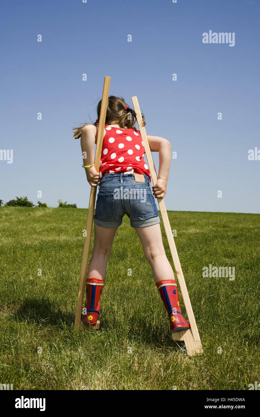 Colline, prati, ragazza, stilt in esecuzione, vista posteriore, Foto Stock