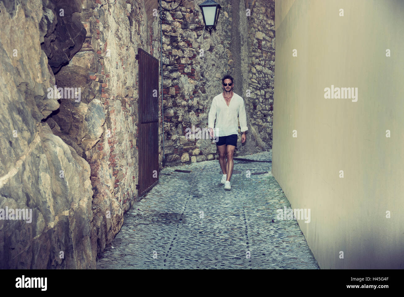 Elegante uomo a camminare in città vecchia verso la telecamera Foto Stock