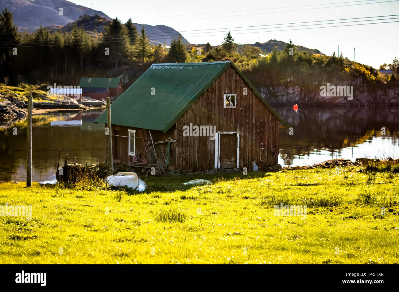 Cottage di legno casa al lago norvegese nel paesaggio autunnale Foto Stock