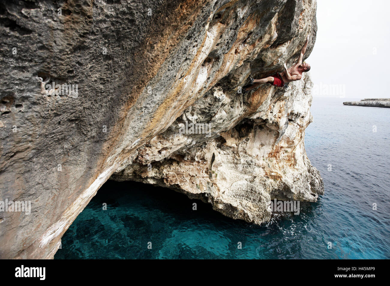 Toni Lamprecht, Spagna, Maiorca, acqua profonda assolo, sul mare nelle isole Baleari, alpinista professionista, alpinista, uomo, persone, vista laterale, sport, sport estremi, il freeclimbing, Psicobloc, arrampicata, forza, ceppo, sfida, avventura, concentrazione, rock, rock arch, scogliere, Baia Mare Mediterraneo, Foto Stock