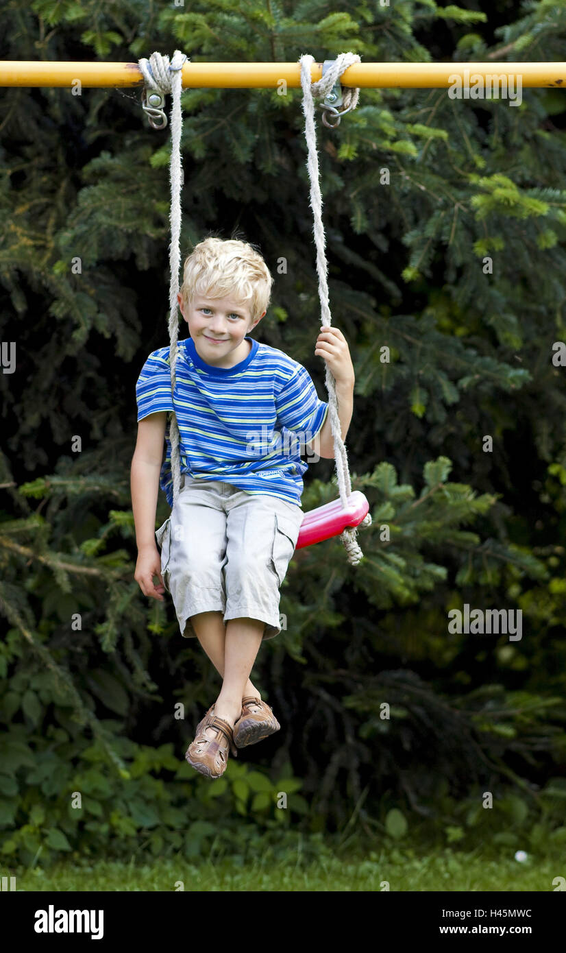 Un ragazzo, 5 anni, si siede su un altalena, modello rilasciato, Foto Stock
