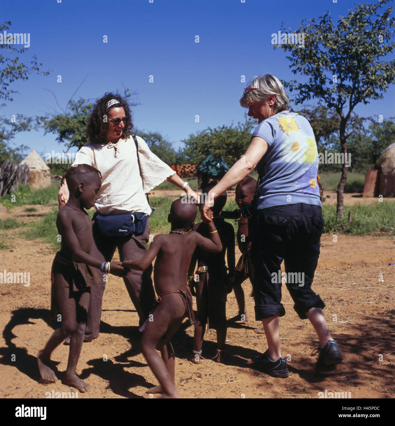 La Namibia, Kamanjab, ceppo Himba, bambini, donne turistica, play, Africa sudoccidentale, Africa, persona, locali Himba, tribù, tribù, Himba bambini, turisti, donne, danza, divertimenti, divertente incontro, Foto Stock