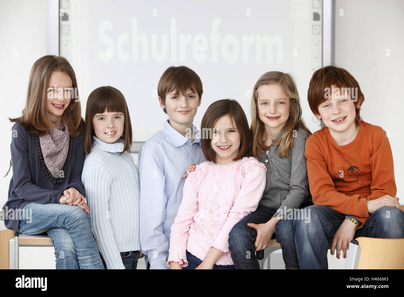 I bambini, gli alunni, classroom, seduto o in piedi, guardando la telecamera, Foto Stock